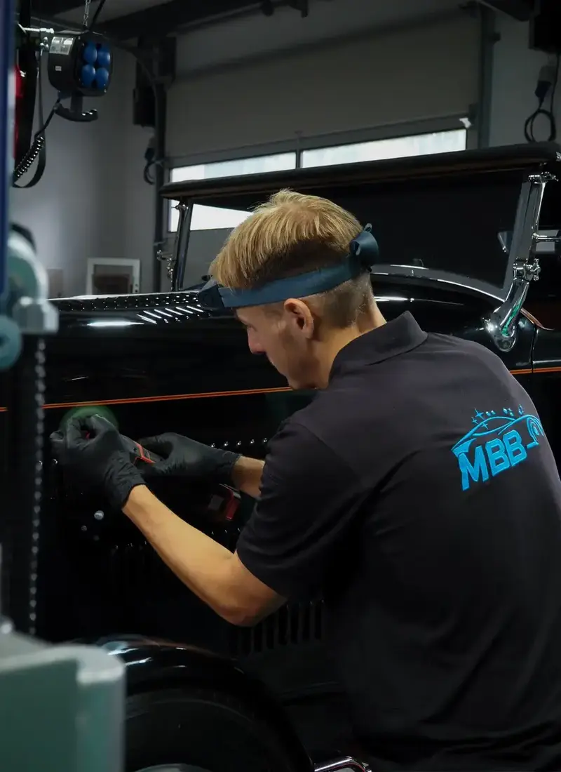 Detailarbeit an den Lüftungsschlitzen eines schwarzen Oldtimers – präzise Politur durch MBB Fahrzeugaufbereitung mit professionellem Equipment.